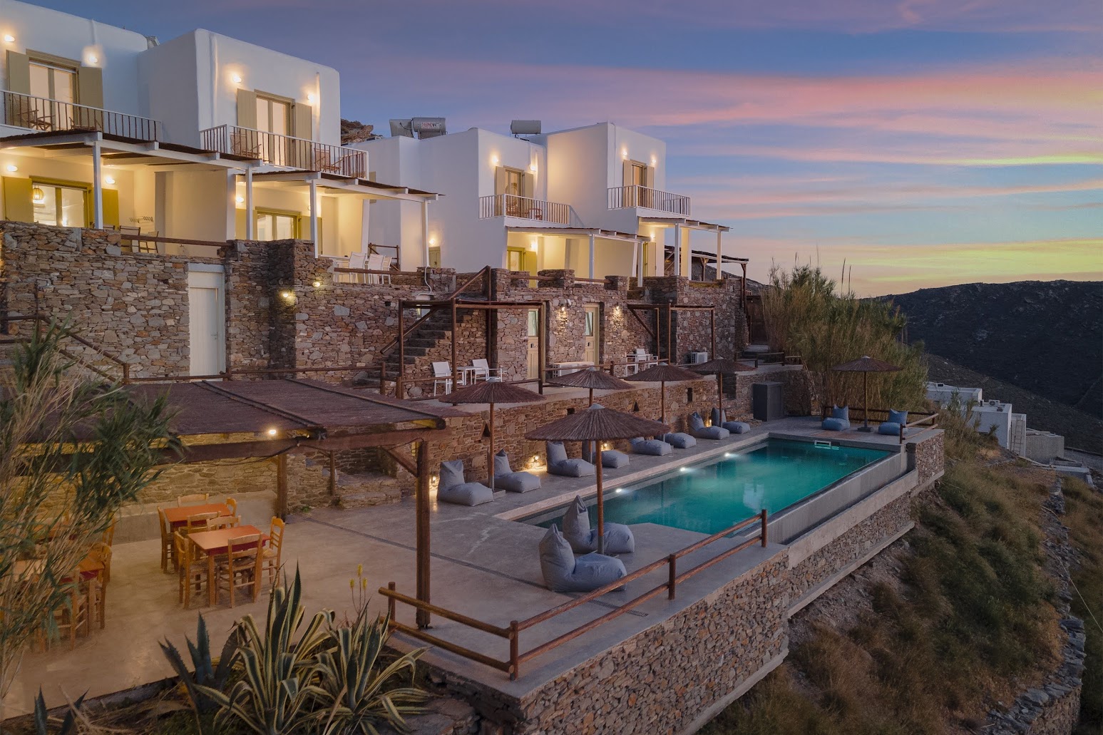 Kastellas Villas at dusk — pool, terraces and stone architecture, Kythnos, Cyclades