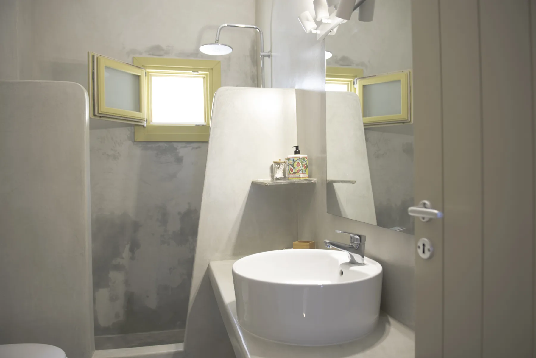 The Maisonette bathroom — lime-plaster shower, yellow window and round basin