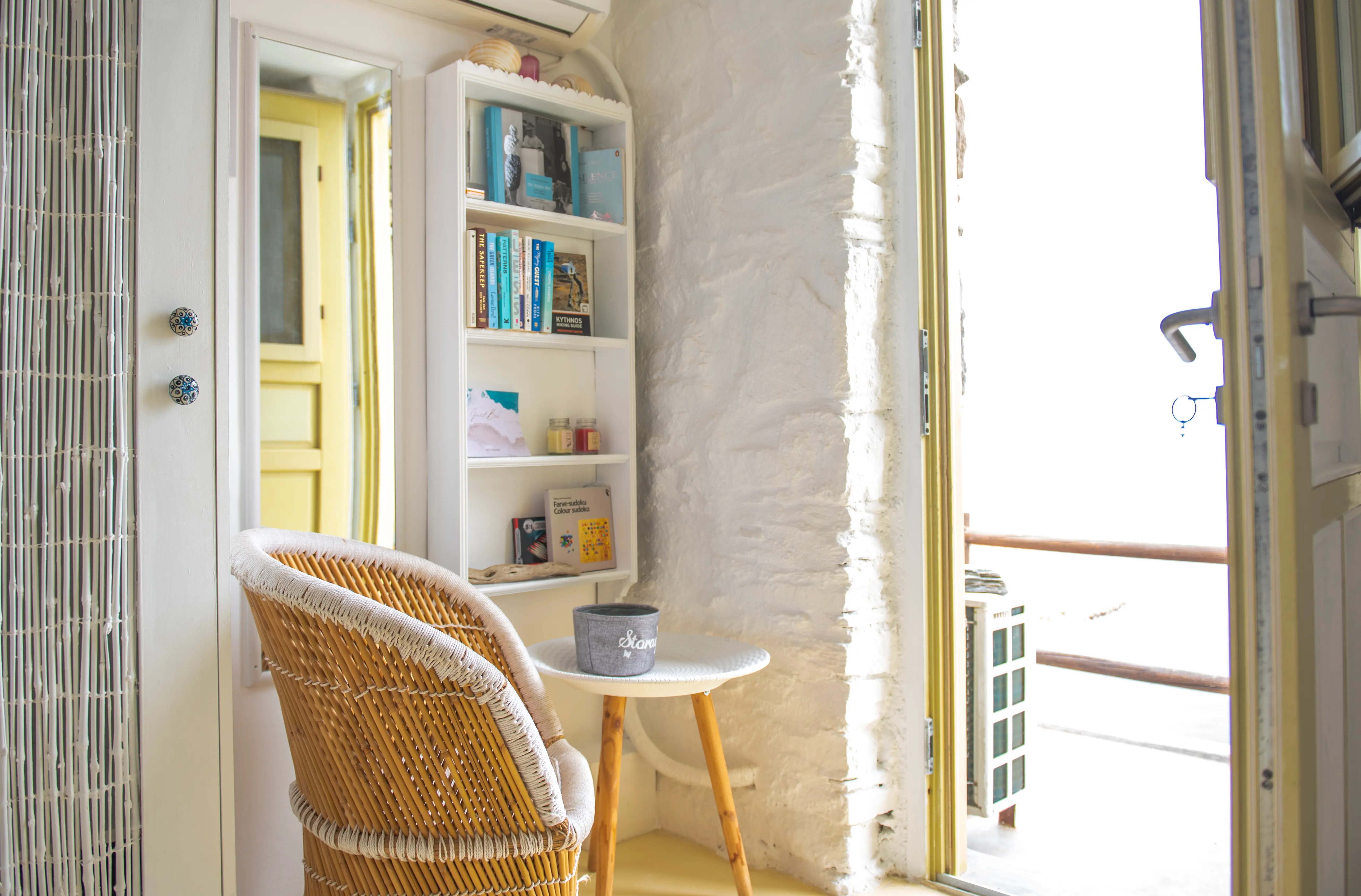 Reading corner with rattan chair, bookshelf and sea view, The Studio