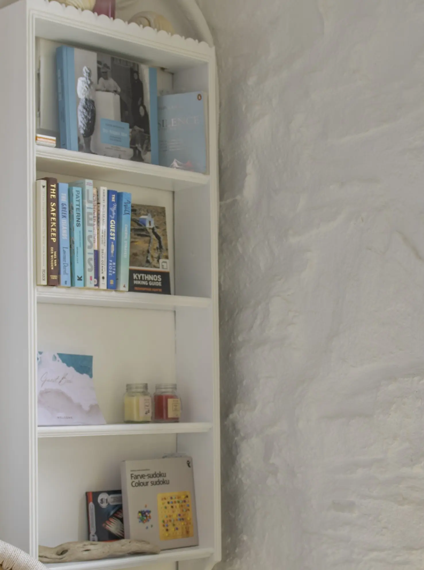 Curated bookshelf with Kythnos hiking guide and local books, The Studio
